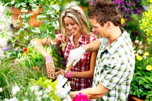 Lawn care technician trimming a garden in Rotherhithe